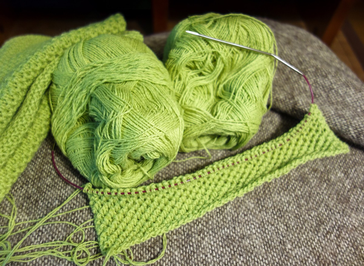 A half-brioche stitch swatch in lime green merino yarn on the needles