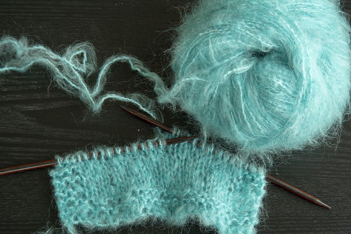 A skein of mohair yarn beside a knitted sample